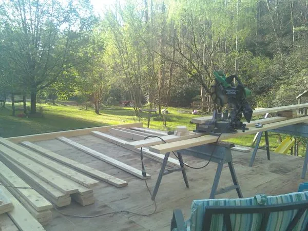 Miter saw and framing lumber on a deck under construction in Waterford